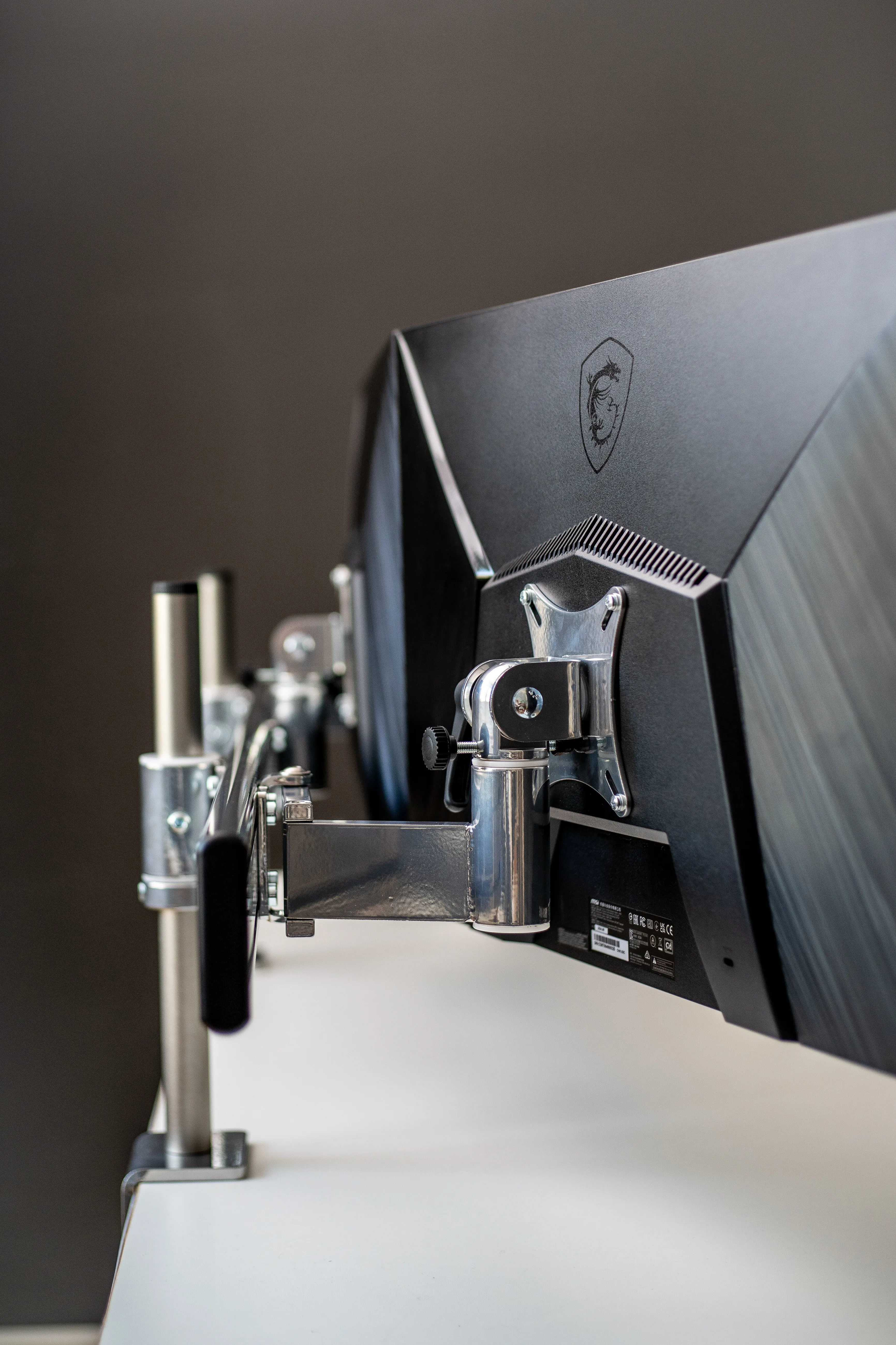 Stabile Tischklemme-Halterung in Chrom für drei Monitore nebeneinander mit unterschiedlichen VESA-Aufnahmen